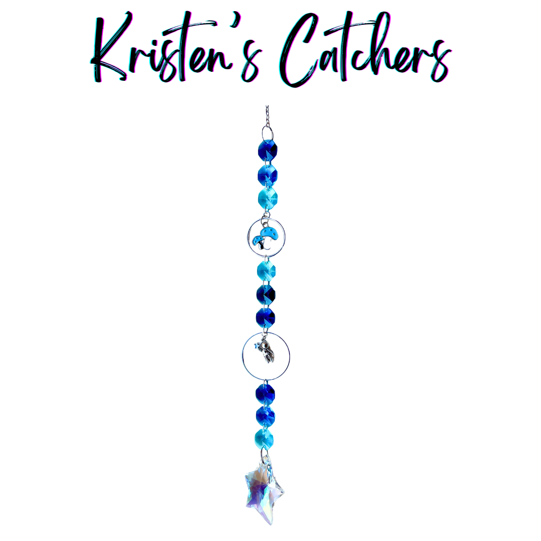 Handcrafted single strand sun catcher with silver astronaut charm, blue mushroom charm, deep royal and teal blue faceted beads, and an iridescent A/B star-shaped pendant drop