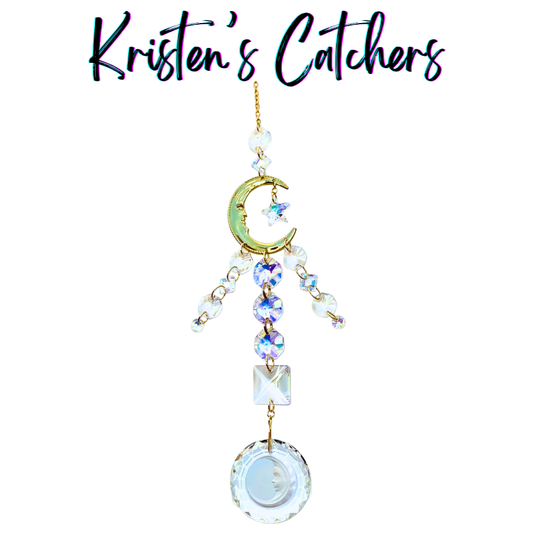Handcrafted Artemis-inspired sun catcher with gold crescent moon connector, star charm, stacked A/B heart crystals, iridescent fringe, and a clear moon face circle pendant drop.