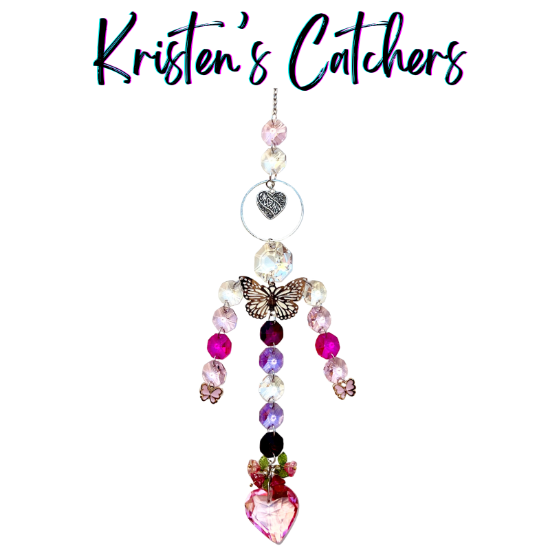 Handcrafted Mother's Day sun catcher with silver filigree butterfly, mom heart charm, pink flower accents, cascading pink and lavender crystals, and a rose-crowned pink heart pendant.