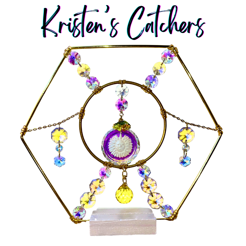 Handcrafted gold hexagon tabletop sun catcher with carved sun face disc, gold ring connector, A/B crystal frame edges, flower crystal accents, and yellow ball pendant. Includes display stand.