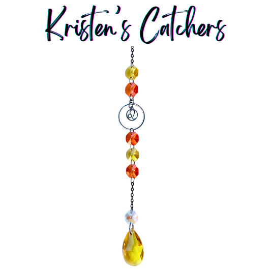 Leo zodiac sun catcher with gunmetal lion symbol centerpiece featuring yellow and red crystals with black chain