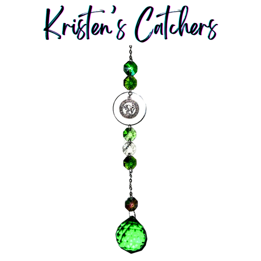 Silver Taurus sun catcher with emerald green crystal accents and clear prisms creating dancing light patterns