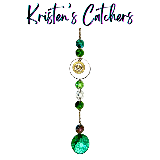 Gold Taurus sun catcher with emerald green crystal accents and clear prisms creating dancing light patterns