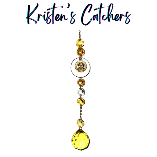 Gold Gemini sun catcher with amber crystal accents and clear prisms creating dancing light patterns
