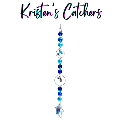 Handcrafted single strand sun catcher with silver astronaut charm, blue mushroom charm, deep royal and teal blue faceted beads, and an iridescent A/B star-shaped pendant drop
