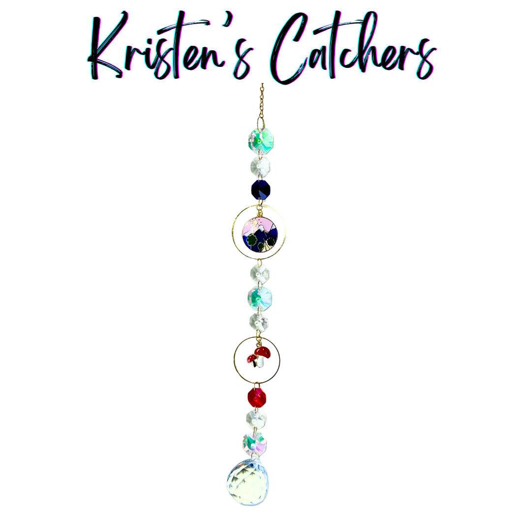 Handcrafted single strand sun catcher with illustrated mountain scene pendant, red enamel mushroom charm, iridescent teal and clear beads, red crystal accent, gold hardware, and a large clear iridescent ball pendant drop