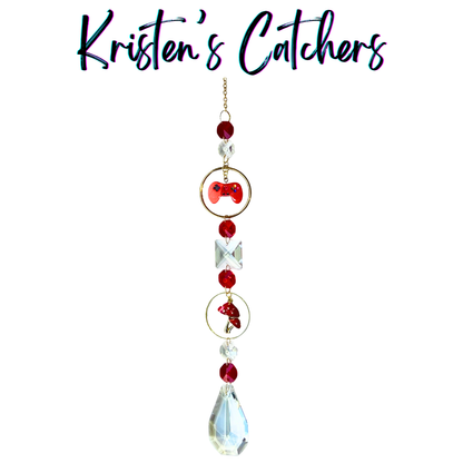 Handcrafted single strand sun catcher with red enamel game controller charm, red mushroom charm, deep red faceted beads, large clear square crystal, gold hardware, and a clear A/B teardrop pendant drop