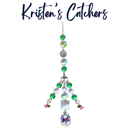 Handcrafted sun catcher with silver lotus charm, ornate heart connector, green and iridescent A/B beads, pink flower accents, and a large A/B teardrop pendant drop.