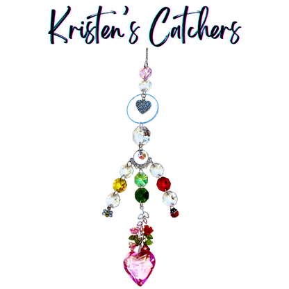 Handcrafted Mother's Day garden sun catcher with ladybug and bee charms, mom heart, rose accents, multi-color crystal strands, and a large pink heart pendant drop.