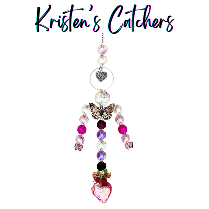 Handcrafted Mother's Day sun catcher with silver filigree butterfly, mom heart charm, pink flower accents, cascading pink and lavender crystals, and a rose-crowned pink heart pendant.
