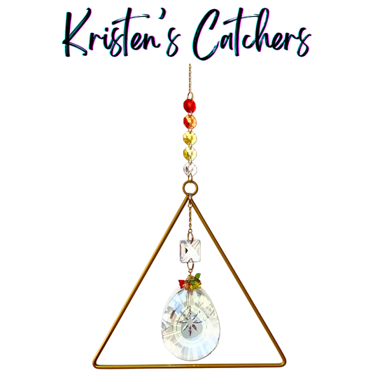 Handcrafted experimental sun catcher with large gold triangle frame, sunburst-etched oval crystal pendant, flame gradient bead header, and square lattice crystal connector.