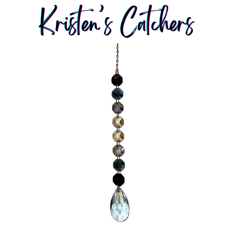 Handcrafted single strand black gradient sun catcher with bronze hardware flowing from deep black through champagne gold to a clear iridescent teardrop pendant drop.