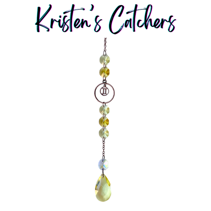 Gemini zodiac sun catcher with twins symbol centerpiece featuring yellow and champagne crystals with rose gold hardware