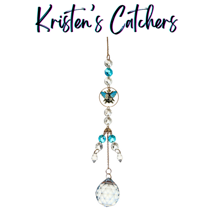 Teal Beetle Bloom Sun Catcher with teal and clear crystals featuring a teal beetle charm, white flower accents, and a large crystal ball prism