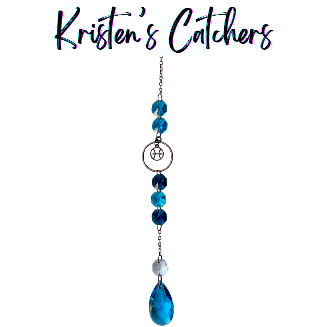 Pisces zodiac sun catcher with fish symbol centerpiece featuring ocean blue and teal crystals with rose gold hardware