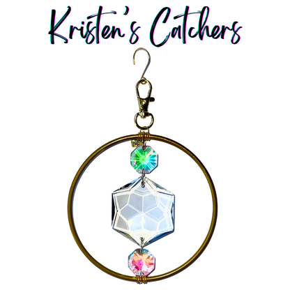 Geometric harmony ornamental sun catcher with 4-inch golden ring, hexagon center prism and pink green A/B crystals