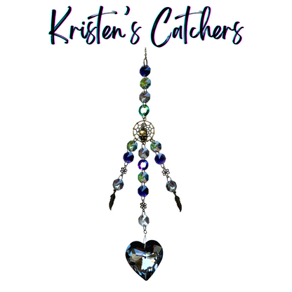 Handmade gothic sun catcher with silver skull charm and deep blue heart creating dramatic romantic reflections