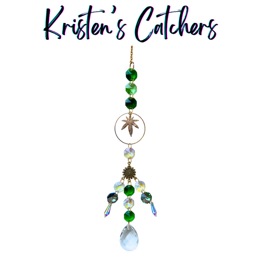 Handmade gold grass leaf sun catcher with emerald and aurora borealis glass creating luxe botanical reflections