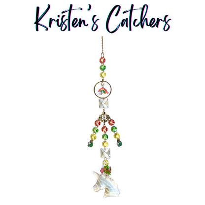 Handcrafted sun catcher with large iridescent unicorn prism pendant, enamel rainbow charm, ornate bronze filigree connector, pastel pink green and yellow faceted beads, green flower charms, and clear square crystal connectors