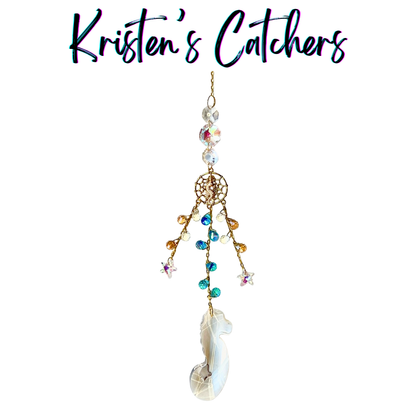 Handcrafted sun catcher with large iridescent seahorse prism pendant, gold woven net connector with seahorse charm, cascading teal amber and iridescent micro crystal fringe, A/B star charms, and large shifting iridescent header beads