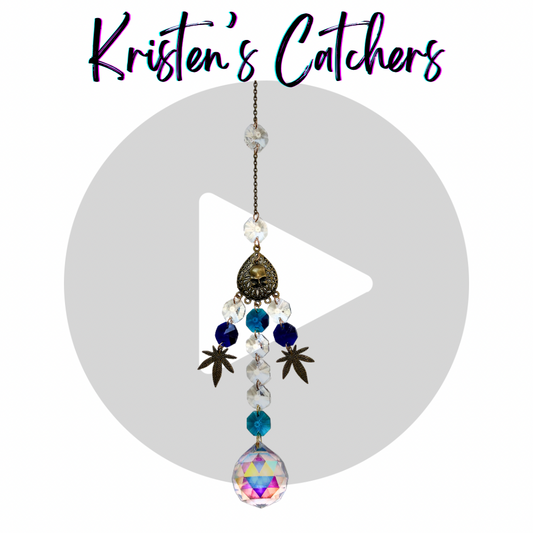 Blazing Buds sun catcher with A/B coated and dark blue crystals, bronze weed leaf and a skull charms.