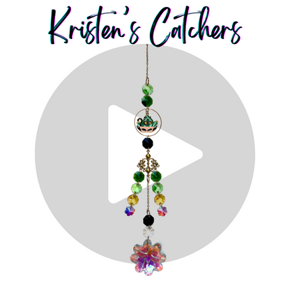 black cat in a green plant gold sun catcher